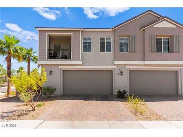 Charming townhome featuring a private balcony and two-car garage, enhanced by lush palm trees and desert landscaping at 295 Callen Falls Ave # 2225, Henderson, NV 89011