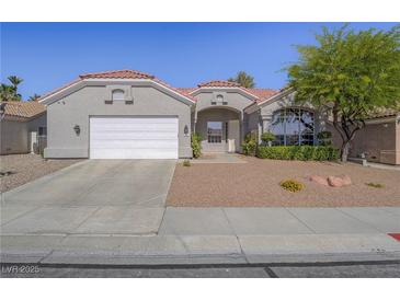 Charming single-story home featuring a red tile roof, landscaped front yard and a two car garage at 401 Obsidian St, Las Vegas, NV 89145