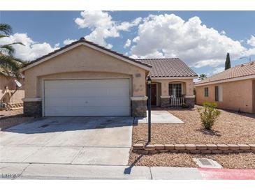 Inviting single-story home showcasing a two-car garage, desert landscaping, and a charming covered porch at 5528 Morningcross St, Las Vegas, NV 89130