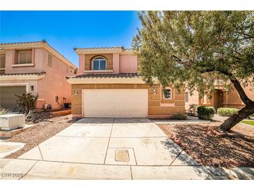 Two-story tan home with a two-car garage and desert landscaping in front at 6747 Gold Yarrow St, Las Vegas, NV 89148