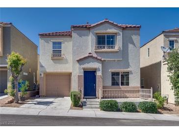 Charming two-story home with a tan stucco exterior, a blue front door, and a cozy front porch at 9140 Entrancing Ave, Las Vegas, NV 89149