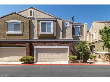 Townhouse shows brick accents and attached garages for convenient parking at 939 Paisley St, Las Vegas, NV 89145