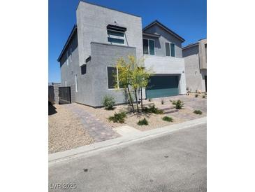 Modern two-story home with a minimalist design, desert landscaping, and a two-car garage at 10021 Locking Biner Ave, Las Vegas, NV 89166