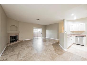 Open-concept living area with tile floors, fireplace, and sliding door access at 2050 W Warm Springs Rd # 4322, Henderson, NV 89014