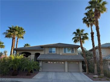 Charming two-story home featuring a neutral palette, tile roof, attached two-car garage, and mature palm trees at 2440 Ping Dr, Henderson, NV 89074