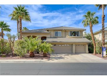 Beautiful two-story home with a tile roof, three car garage, and lush desert landscaping at 2440 Ping Dr, Henderson, NV 89074