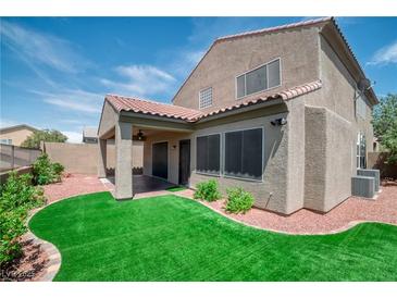 View of the house with a covered patio and a well-maintained lawn surrounded by decorative rock at 2529 Flodden St, Henderson, NV 89044