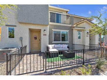 Charming townhouse with a cozy, fenced front patio seating area and a modern, neutral color scheme at 2598 Polar White Ave, North Las Vegas, NV 89086