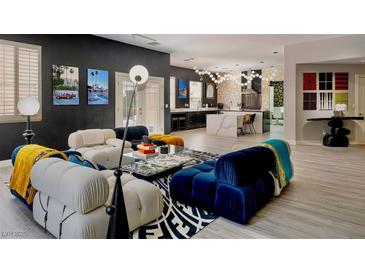 Modern living room with stylish furniture, light wood floors and a view into the kitchen at 464 Beardsley Cir, Henderson, NV 89052