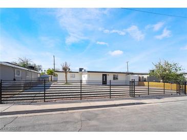 Charming single-story home featuring secure fencing, a modern aesthetic, and well-maintained landscaping at 5069 Hallet Dr, Las Vegas, NV 89122