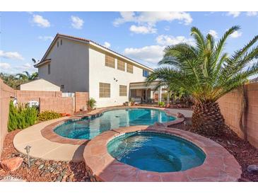 Inviting backyard pool and spa with lush landscaping and privacy fencing at 977 Courtney Valley St, Henderson, NV 89052