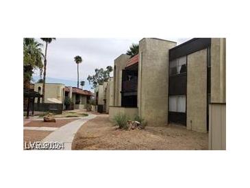 View of the apartment complex exterior with desert landscaping, palm trees, and walkway at 1405 Vegas Valley Dr # 360, Las Vegas, NV 89169
