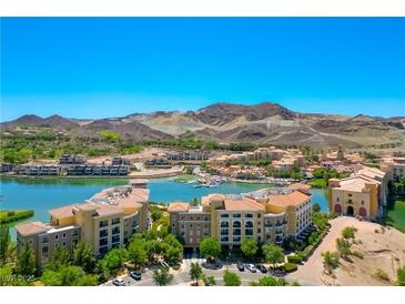 Stunning aerial view of a lakeside community with mountain backdrop and meticulously designed buildings under a clear blue sky at 29 Montelago Blvd # 520, Henderson, NV 89011