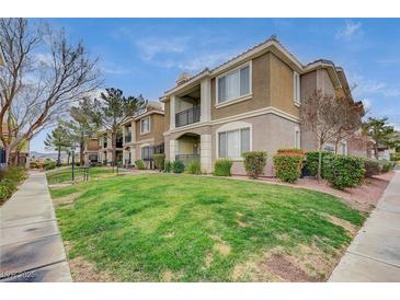 Beautiful two-story condo building with a well-manicured lawn and balcony views on a partly cloudy day at 2900 Sunridge Heights Pkwy # 518, Henderson, NV 89052