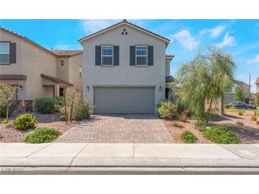 Charming two-story home with a brick driveway, gray exterior, and manicured landscaping at 2935 Saltillo Ln, Las Vegas, NV 89121