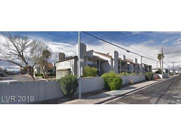 The exterior of this apartment building has a cinder block wall and ample landscaping around the property at 2981 Country Manor Ln # 118, Las Vegas, NV 89115