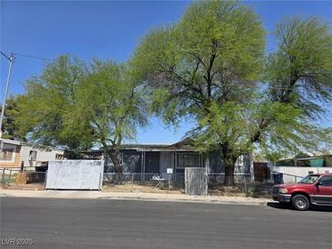 Charming single-story home with mature trees and a chain-link fenced yard at 4794 Saguaro Way, Las Vegas, NV 89121
