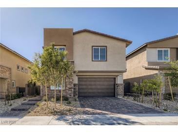 Charming two-story home featuring a brick-accented facade, two-car garage, and manicured landscaping at 9576 Archer Peak Ct, Las Vegas, NV 89143