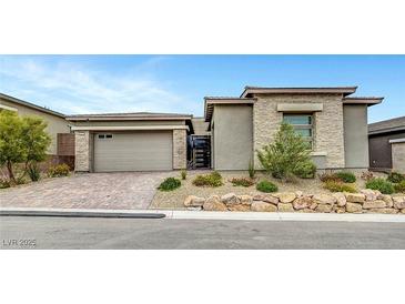 Charming single-story home featuring a stone facade, desert landscaping, and brick driveway at 977 Edinburgh Fields Ct, Las Vegas, NV 89138