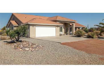 Charming single-story home featuring a spacious driveway and an attached two-car garage at 3430 Flagstone Ct, Pahrump, NV 89048