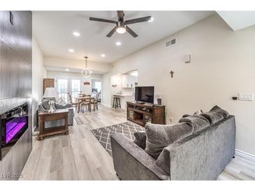 Bright living room with a modern fireplace, ceiling fan, and lots of natural light at 4437 Alto Verde Dr, Las Vegas, NV 89119