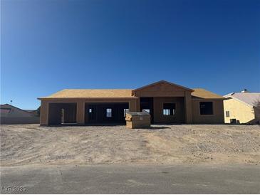 Unfinished house with two-car garage shows the framing under construction, with blue sky overhead at 6670 White Eagle Dr, Pahrump, NV 89061