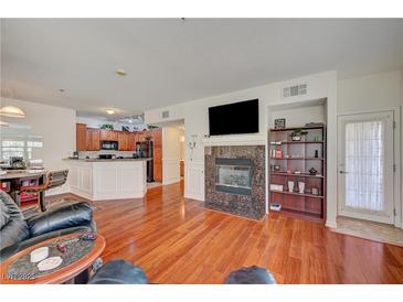 Bright living room featuring hardwood floors, a fireplace, and an open layout to the kitchen at 689 Bay View Dr # 1311, Boulder City, NV 89005