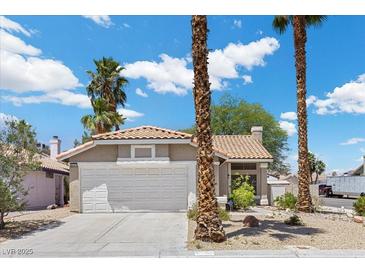 Charming single-story home features a well-manicured front yard, a two-car garage, and a classic stucco facade at 6997 Ray Charles Ln, Las Vegas, NV 89119