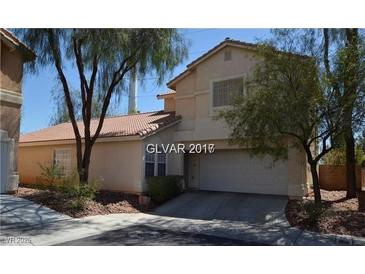 Charming two-story home featuring a tiled roof, desert landscaping, and an attached two-car garage at 7518 Luna Del Rey St, Las Vegas, NV 89123
