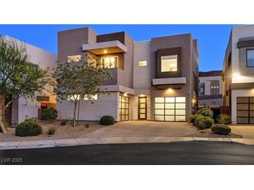 Contemporary two-story home with modern design, stone accents, two-car garage, and desert landscaping at 881 Barrhead Ave, Henderson, NV 89012