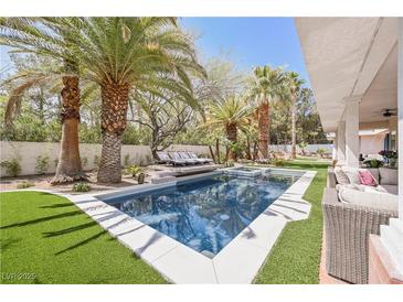 Inviting backyard pool with lush landscaping and lounge chairs for ultimate relaxation and outdoor enjoyment at 2231 S Tioga Way, Las Vegas, NV 89117
