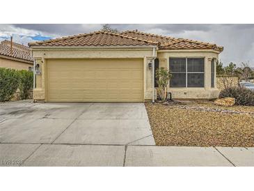 Charming single-story home showcasing a well-maintained lawn, a two-car garage, and a classic tile roof at 3473 Conough Ln, Las Vegas, NV 89129