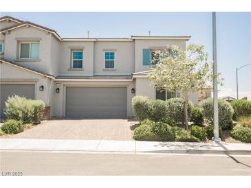 Charming two-story townhome featuring a neutral color palette and manicured landscaping at 7002 Fossil Rim St, North Las Vegas, NV 89084