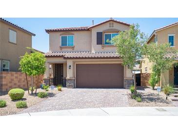 Two-story home features a desert landscape, a brick driveway, and a two-car garage at 871 Aurelie Ridge St, Henderson, NV 89011