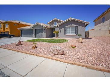 Charming single-story home featuring a well-manicured yard, neutral tones, and a two-car garage at 1519 Deerford Cir, Las Vegas, NV 89110