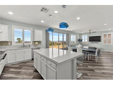 Bright kitchen with a large island, white cabinets, stainless steel appliances, and wood flooring at 424 Vigo Port St, Las Vegas, NV 89138
