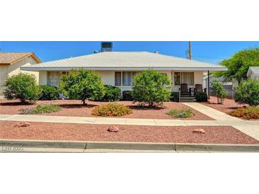 Charming single-story home featuring well-maintained landscaping with mature trees and plants in the front yard at 557 6Th St, Boulder City, NV 89005