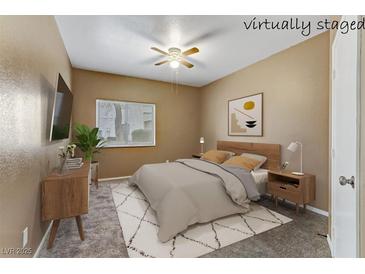 This staged bedroom offers a ceiling fan and a comfy-looking bed at 5655 E Sahara Ave # 1052, Las Vegas, NV 89142