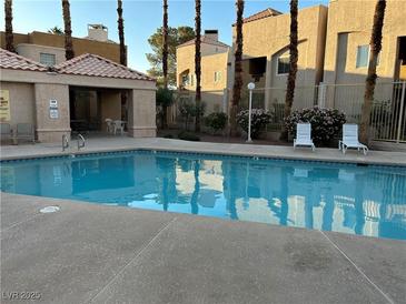 Inviting community pool with lounge chairs, perfect for relaxation and enjoying the outdoors at 6865 Tamarus St # 202, Las Vegas, NV 89119