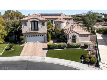 Beautiful two-story home with a landscaped yard, brick driveway, and a two-car garage at 9301 Queen Charlotte Dr, Las Vegas, NV 89145