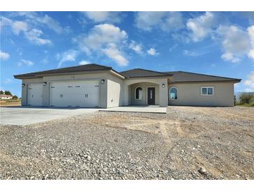 Inviting single-story home with a spacious three-car garage and low-maintenance desert landscaping at 1580 S Tiptop Trl, Pahrump, NV 89048