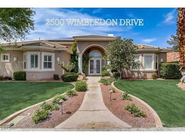 Charming single-story home with a well-manicured front yard and a welcoming arched entryway at 2500 Wimbledon Dr, Las Vegas, NV 89107