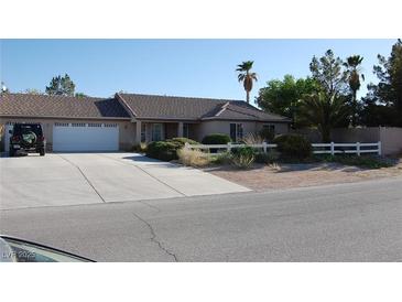 Charming single-story home featuring a well-manicured front yard and a spacious driveway at 30 Diamond Bar Rd, Pahrump, NV 89048