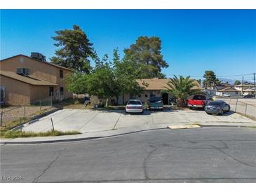 A well-placed view of the property, showcasing the dwelling, yard and several parked vehicles in the driveway at 4 Britz Cir, North Las Vegas, NV 89030