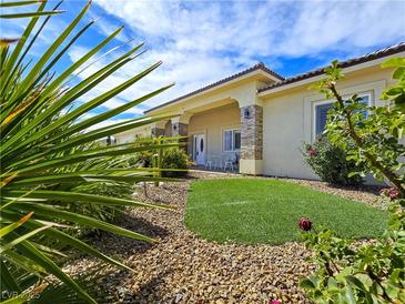 Charming home with green grass, decorative rocks, tasteful landscaping, and a welcoming front porch at 5500 Santovito St, Pahrump, NV 89061
