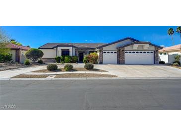 Inviting single-story home with a well-manicured lawn, three-car garage, and mature landscaping at 7461 Tahoe Basin Dr, Las Vegas, NV 89129