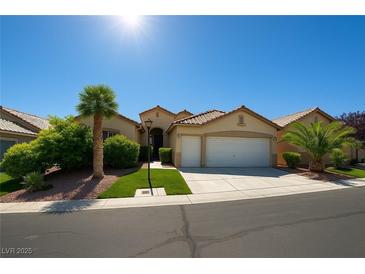 Charming single-story home boasts a well-manicured lawn, desert landscaping, and an attached two-car garage at 10645 Alpine Frost Ct, Las Vegas, NV 89129