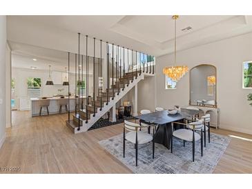 Bright dining area featuring a unique staircase design and modern light fixture at 11550 Lampeter Ct, Las Vegas, NV 89138