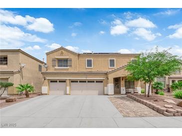Charming two-story home featuring a three car garage, desert landscaping, and covered front entryway at 1808 Peyton Stewart Ct, North Las Vegas, NV 89086