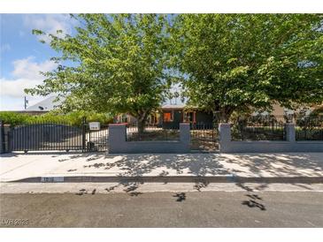 Charming home with an eye-catching wrought-iron gate and mature trees, offering both curb appeal and privacy at 1916 Canosa Ave, Las Vegas, NV 89104
